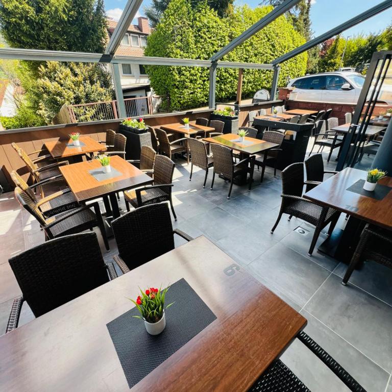 Überdachte Terrasse des Restaurants Toscana mit gedeckten Tischen